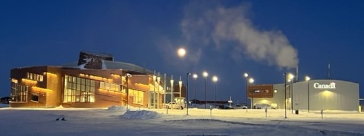 Winter night view of the CHARS Main Research Building and Field Maintenance Building. The moon hangs in the sky between the buildings.